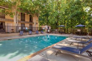 einen Pool mit Stühlen und Sonnenschirmen in der Unterkunft Best Western Plus Cary - NC State in Cary