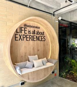 a round wooden bench with a sign on a wall at beminimal Hotel in Medellín