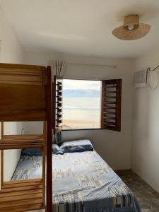 - une chambre avec des lits superposés et une fenêtre dans l'établissement Chalés Solmar, à Itapipoca