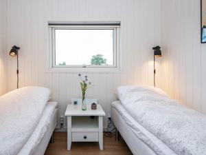 ボルコップにあるHoliday home Børkop IVのベッド2台、テーブル、窓が備わる客室です。