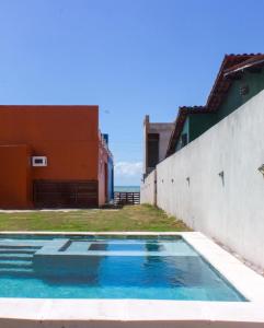 a swimming pool in front of a building at Chalés Solmar in Itapipoca