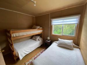 two bunk beds in a small room with a window at Hostería Ensenada in Puerto Puyuhuapi