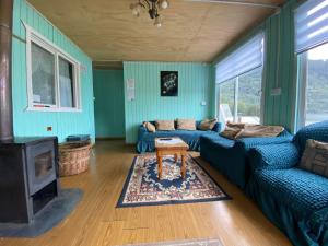a blue living room with a couch and a table at Hostería Ensenada in Puerto Puyuhuapi