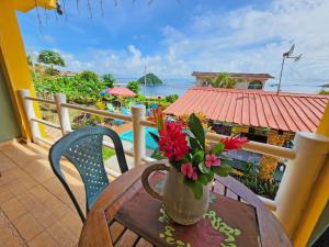 a vase of flowers sitting on a table on a balcony at Cerrito Tropical Eco Lodge in Taboga