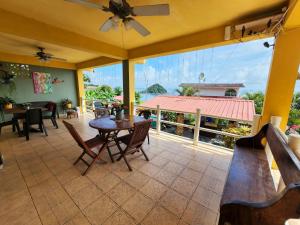 un patio con mesa, sillas y una ventana grande en Cerrito Tropical Eco Lodge, en Taboga