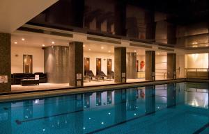 a swimming pool in a building with a living room at Holiday Inn London Kensington High St. by IHG in London