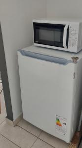 a microwave sitting on top of a refrigerator at Bahia Rental 11-Departamento x dia con cochera in Bahía Blanca