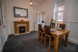 a dining room with a table and a fireplace at Dwellcome Home Ltd 2 Bedroom 3 Bed South Shields Apartment - see our site for assurance in South Shields
