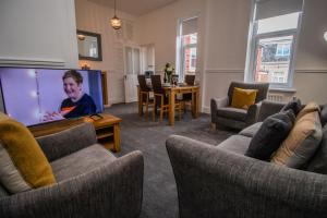 a living room with couches and a large screen tv at Dwellcome Home Ltd 2 Bedroom 3 Bed South Shields Apartment - see our site for assurance in South Shields