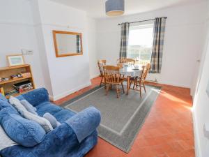 a living room with a blue couch and a table at Bay View Farmhouse in Haverfordwest