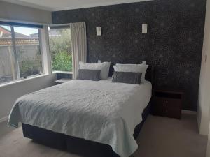 ein Schlafzimmer mit einem großen Bett und einem Fenster in der Unterkunft Pavilion Beachfront Apartments in Mount Maunganui