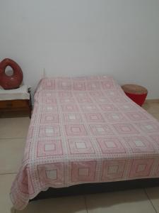 a pink quilt on a bed in a room at La Cloty in Paraná