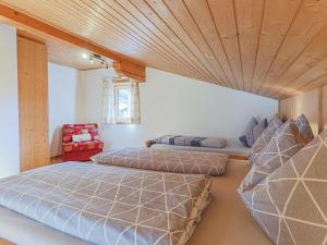 two beds in a room with a wooden ceiling at Boar Hof Top 1 in Kirchberg in Tirol