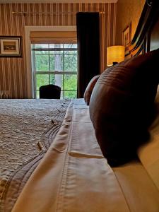 a bedroom with a bed with a couch and a window at Darlington House Bed and Breakfast in Niagara on the Lake