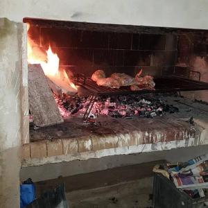 a brick oven with meat cooking in it at Cabaña Suri in Belén de Escobar