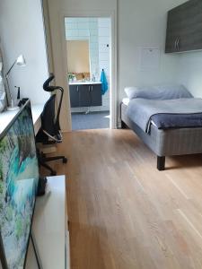 1 dormitorio con 1 cama y escritorio con TV en Studio w centrum miasta Holmestrand, Norwegia, en Holmestrand