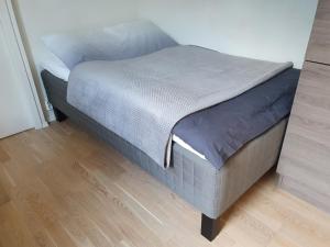 a small bed in a room with a wooden floor at Studio w centrum miasta Holmestrand, Norwegia in Holmestrand