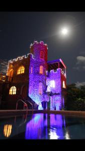 a building with purple lights on it at night at La Fortaleza De Haro in Puerto Ayora