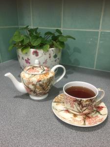 a cup of coffee and a tea pot on a counter at Bird Abode in Maryborough