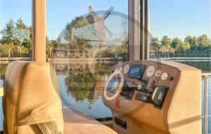 a cockpit of a boat with a windmill in the background at Nice Ship In Havelsee With House Sea View in Kützkow