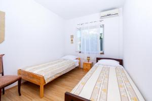 2 Betten in einem Zimmer mit weißen Wänden in der Unterkunft Apartments by the sea Preko, Ugljan - 14917 in Preko