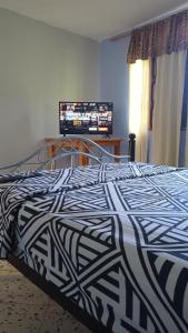 a bed with a black and white comforter in a bedroom at Hotel Villa Mary Apartaestudios playa in Puerto Colombia