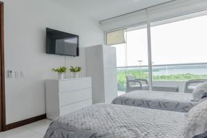 1 Schlafzimmer mit 2 Betten und einem TV an der Wand in der Unterkunft apartamento 1 alcoba morros 922 rnt 132107 in Cartagena de Indias