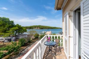 a balcony with a table and chairs and a view of the water at Double Room Pasman 4309d in Pašman