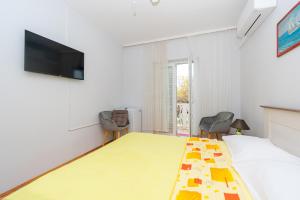 a room with a bed and a flat screen tv at Double Room Pasman 4309e in Pašman