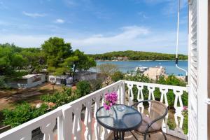 a balcony with a table and a view of the water at Rooms by the sea Pasman - 4309 in Pašman