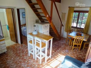 a kitchen with a table and a refrigerator in a room at Cabañas Dunas del Diablo in Punta Del Diablo +4 photos