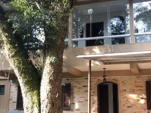 un edificio con un árbol delante de él en Charming Home 2 min. from Barigui Park en Curitiba