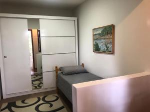 Dormitorio pequeño con cama y espejo en Charming Home 2 min. from Barigui Park en Curitiba