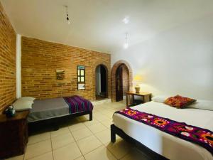 - une chambre avec 2 lits et un mur en briques dans l'établissement HABITACIONES EN VALLARTA 6 CUADRAS MALECON, à Puerto Vallarta