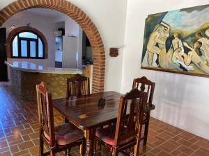 una mesa de madera y sillas en una cocina con una pintura en HABITACIONES EN VALLARTA 6 CUADRAS MALECON en Puerto Vallarta