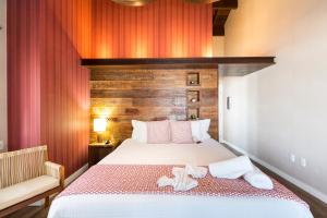 una camera da letto con un letto e asciugamani di Hospedaria Refúgio das Galés a Bombinhas