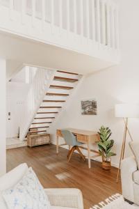 a white living room with a table and stairs at Puamana Maluhia - Two Bedroom / Two Bath Condo in Princeville