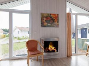 a living room with a fireplace and a chair at 4 person holiday home in GROEMITZ in Grömitz