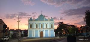 a white building with a cross on top of it at Casa Rosário Centro de Amparo in Amparo +12 photos
