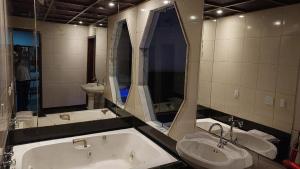 a bathroom with a tub and a sink and a mirror at New Star in Rio de Janeiro