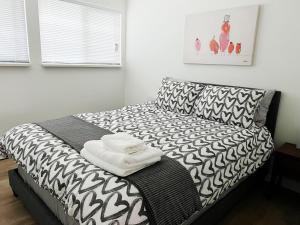 a bedroom with a bed with a black and white blanket at All-ways Home in Burnaby