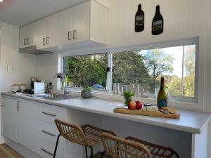 a kitchen with a counter with two bottles of wine at The Nest Tiny Home Mt Irvine in Mount Irvine