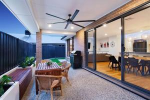 een woonkamer met een plafondventilator en een tafel bij Linear Park Living - Brand New 4 Bed Family Home in Thebarton