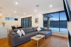 a living room with a couch and a table at Linear Park Living - Brand New 4 Bed Family Home in Thebarton