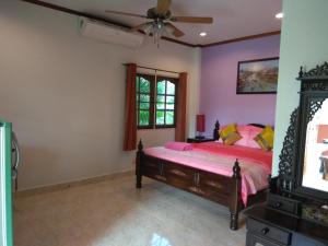 1 dormitorio con 1 cama y ventilador de techo en Stella Resort en Sam Roi Yot