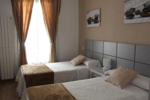 Cette chambre comprend 2 lits et une fenêtre. dans l'établissement Casa de Huéspedes Galaica, à Madrid