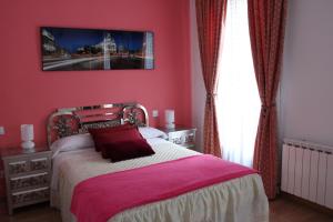 a bedroom with a bed with a pink wall at Casa de Huéspedes Galaica in Madrid