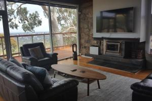 a living room with couches and a fireplace with a tv at Family Home Prestigious Suburb Panoramic Views in Glenunga