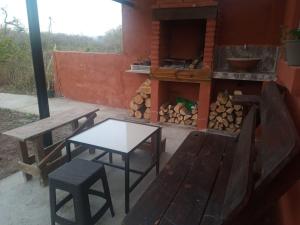 un patio con mesa, banco y parrilla en Aguaribay cabañas en San Javier