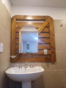 y baño con lavabo y espejo. en Aguaribay cabañas en San Javier